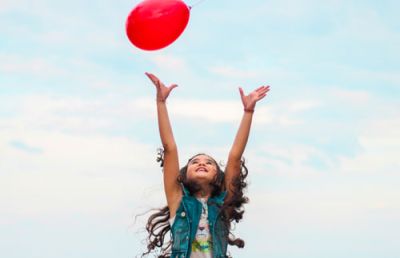 photo d'enfant qui lance un ballon rouge