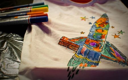 image représentant un dessis sur tissus d'une fusée multicolore qui décolle vers le étoiles